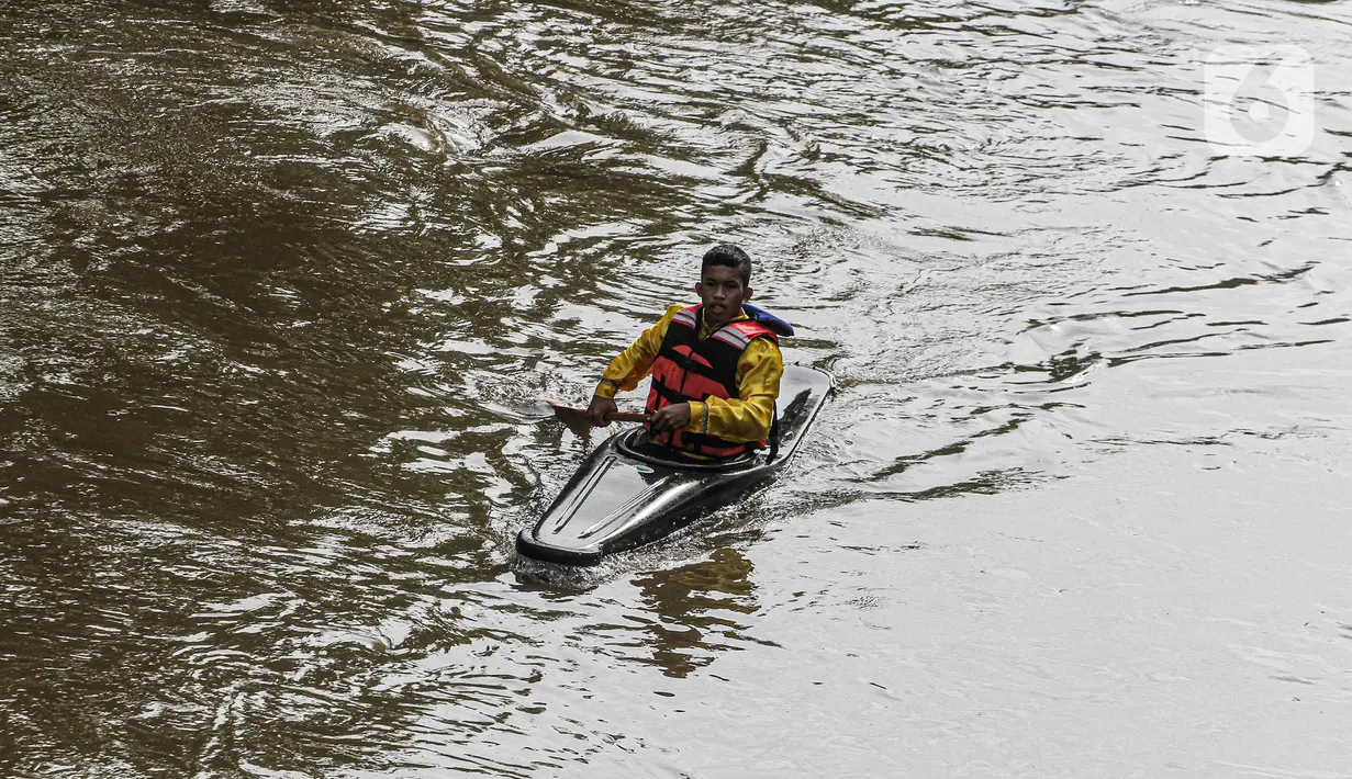Peserta menyusuri Sungai Ciliwung saat mengikuti Festival Dayung Ciliwung, Jakarta, Minggu (4/12/2022). Festival Dayung Ciliwung digelar untuk pemanasan pra-Kejurnas Dayung 2022 sekaligus percontohan pengelolaan sungai di Indonesia. (Liputan6.com/Faizal Fanani)