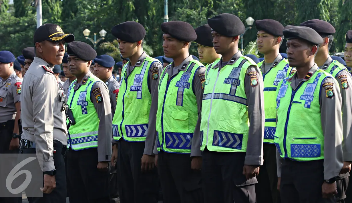Petugas kepolisian mengikuti apel gabungan di Monas, Jakarta, Kamis (31/12). Sebanyak 1300 personel gabungan yang terdiri dari polisi, TNI, Pol PP, dan Pramuka dikerahkan untuk mengamankan perayaan malam tahun baru. (Liputan6.com/Immanuel Antonius)
