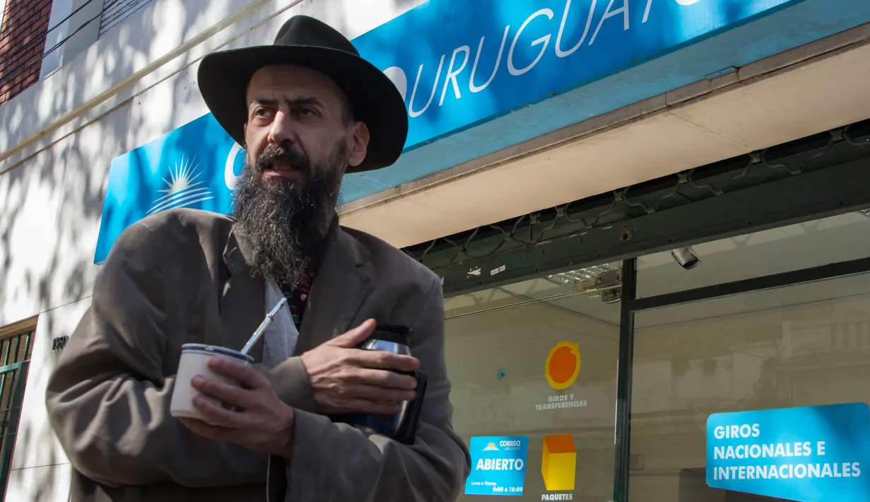 Seorang pria usai mendaftarkan diri sebagai konsumen ganja di kantor pos ibu kota Urugay, Montevideo,  Selasa (2/5). Uruguay mempersilakan warganya menggunakan ganja di mana saja serta membebaskan menumbuhkan mariyuana di rumah. (Pablo PORCIUNCULA/AFP )