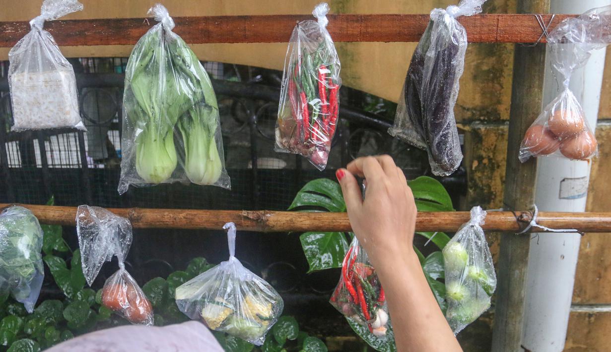 Barang-barang tersebut dikumpulkan oleh panitia untuk kemudian disalurkan kepada masyarakat yang membutuhkan di lingkungan setempat. Tampak dalam foto, warga memilih beberapa bahan masakan yang dibagikan secara cuma-cuma di permukiman RT 02/RW 04 kawasan Jati Padang, Jakarta, Jumat (6/3/2026). (merdeka.com/Arie Basuki)