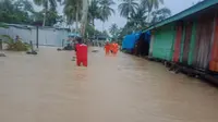 Petugas dari BPBD Nunukan terus berusaha membantu warga untuk keluar dari rendaman banjir dan menyelamatkan barangnya. (foto: Liputan6.com/BNPB)