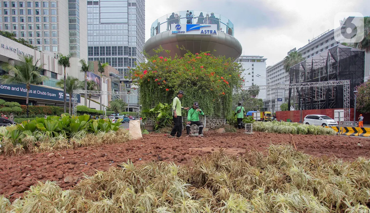 Petugas Dinas Pertamanan dan Hutan Kota Provinsi DKI Jakarta menaikkan tanaman hias yang rusak ke truk di kawasan Bundaran HI, Jakarta, Senin (1/1/2024). Sejumlah tanaman di kawasan Bundaran HI rusak akibat terinjak-injak pada perayaan malam Tahun Baru 2024. (merdeka.com/Arie Basuki)