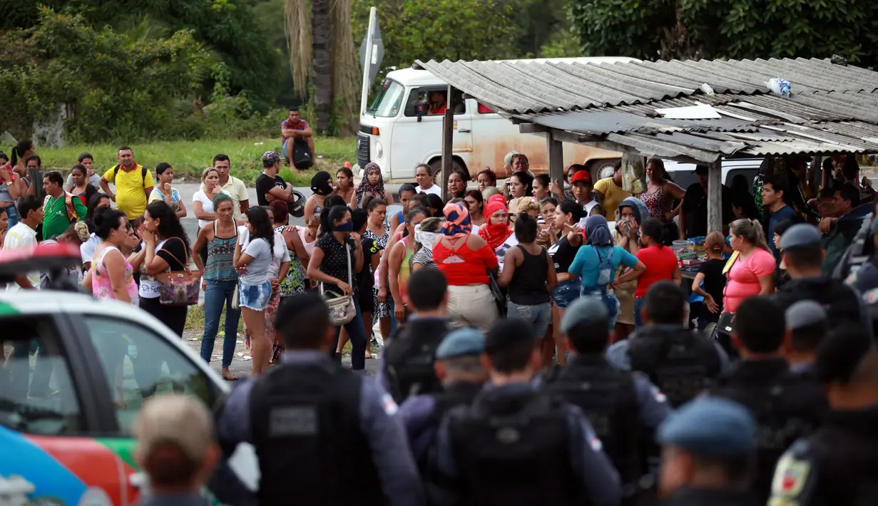 Polisi anti huru hara berjaga di pos pemeriksaan tempat kerabat dari para narapidana berkumpul menyusul kerusuhan yang terjadi di dalam penjara kota Amazon, Brasil, Senin (2/1). Setidaknya 60 orang tewas dalam kerusuhan di penjara (REUTERS/Michael Dantas)