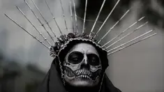 Seorang wanita mengenakan kostum tengkorak menunggu dimulainya Prosesi Grand Catrinas, untuk menandai perayaan Day of The Dead, di Mexico City, Minggu (22/10). Dalam prosesi tersebut warga berdandan menyerupai kerangka. (AP/Rebecca Blackwell)