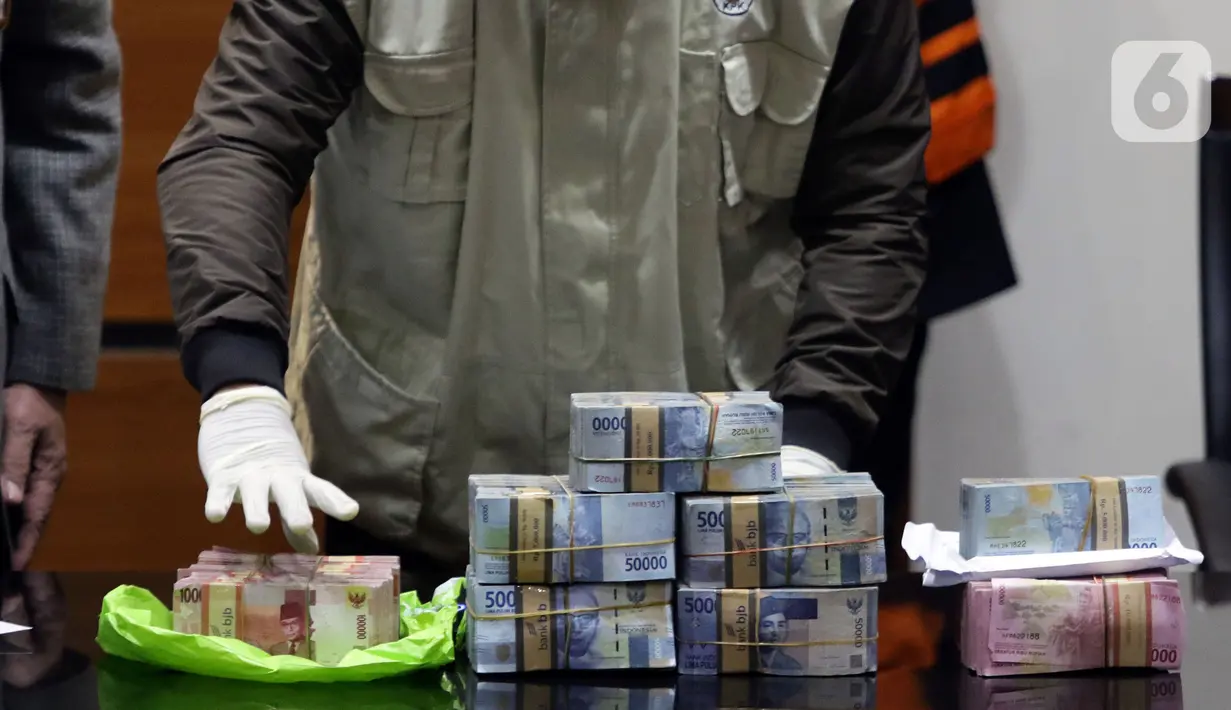 <p>Petugas KPK menunjukkan barang bukti penangkapan Bupati Bogor periode 2018-2023, Ade Yasin di Gedung KPK, Jakarta, Kamis (28/4/2022). KPK menyita uang sejumlah Rp1,024 miliar yang terdiri dari uang tunai Rp570 juta dan dalam rekening bank senilai Rp454 juta. (Liputan6.com/Helmi Fithriansyah) </p>