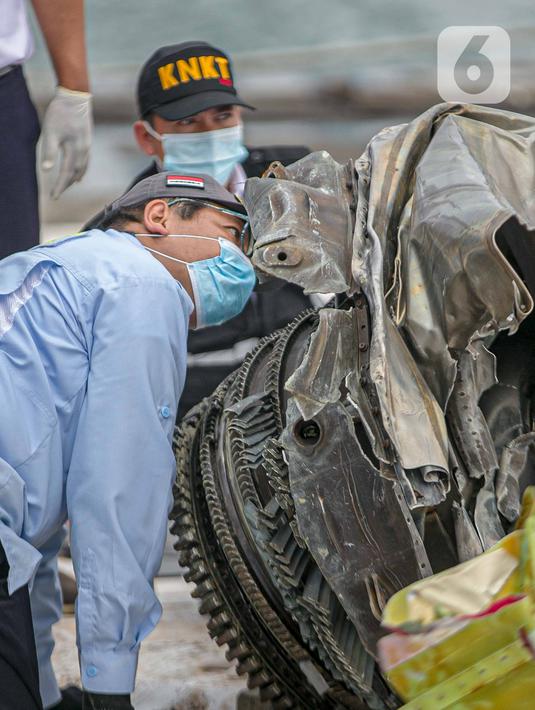 Petugas KNKT memeriksa bagian turbin pesawat Sriwijaya Air dihari kelima yang jatuh di perairan Pulau Seribu, di Dermaga JICT, Jakarta,  Rabu (13/1/2021). Pesawat Sriwijaya Air SJ 182 rute Jakarta-Pontianak  jatuh di perairan Kepulauan Seribu Sabtu (9/1) petang. (Liputan6.com/Faizal Fanani)