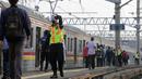Petugas stasiun memandu penumpang KRL Commuterline di Stasiun Bogor, Jawa Barat, Selasa (9/6/2020) pagi. Puluhan polisi, TNI, Satpol PP, dan petugas stasiun diterjunkan untuk memandu penumpang mengantisipasi antrean panjang seperti kemarin. (merdeka.com/Arie Basuki)