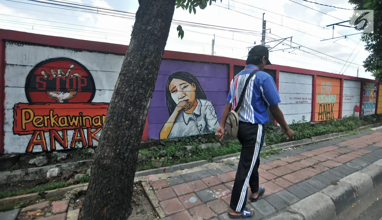 Pejalan kaki berjalan di depan mural bertema 'Tolak Kekerasan Perempuan dan Pelecehan Seksual' di Jatinegara, Jakarta, Senin (17/12). Mural tersebut dibuat untuk meningkatkan kesadaran akan ancaman bahaya pelecehan seksual. (Merdeka.com/Iqbal S. Nugroho)