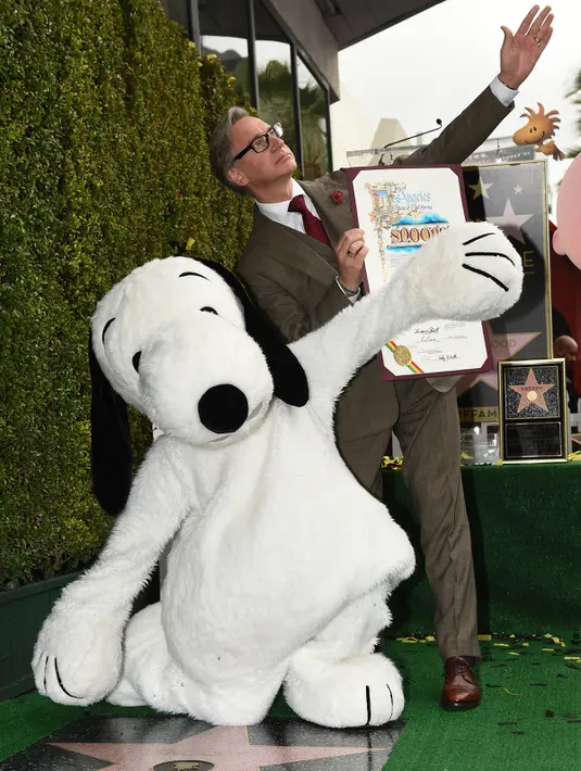Produser Paul Feig dan Snoopy berpose di atas penghargaan Walk of Fame atas nama Snoopy pada upacara penghargaan di Holywood, California, Senin (2/11). (AFP PHOTO/Robyn Beck)