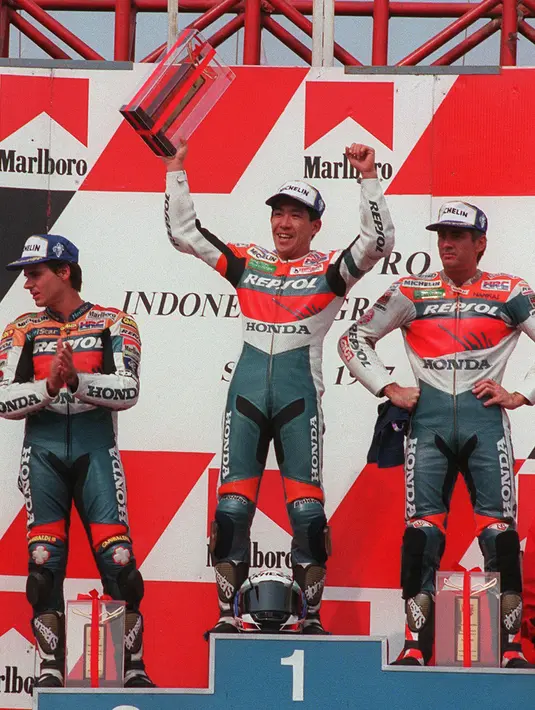 Pebalap Repsol Honda asal Jepang Tadayuki Okada (tengah) mengangkat trofi dengan pebalap Repsol Honda asal Australia Mick Doohan (kanan) dan pebalap Repsol Honda asal Spanyol Alex Criville (kiri) pada World Championship Marlboro Indonesian Grand Prix di Sirkuit Sentul, 28 September 1997. (STR/AFP)