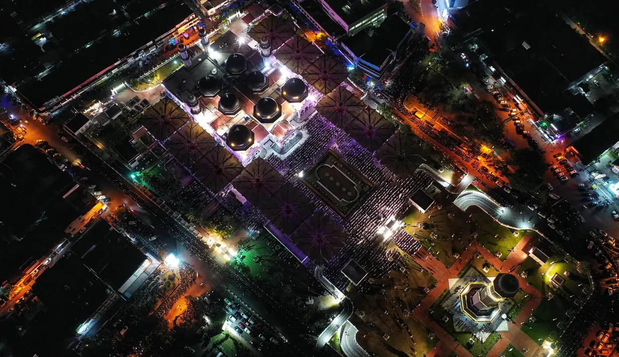 Banyaknya orang yang ingin menunaikan ibadah sholat tarawih sudah tampak dari setiap pintu masuk masjid. (CHAIDEER MAHYUDDIN/AFP)