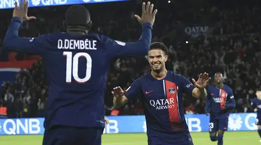 Gelandang Paris Saint-Germain (PSG) Warren Zaire-Emery, tengah, berselebrasi bersama Ousmane Dembele setelah mencetak gol kedua timnya ke gawang Montpellier pada laga Ligue 1 2023/2024 pekan 11 di Parc des Princes, Sabtu (4/11/2023) dini hari WIB. (AP Photo/Aurelien Morissard)