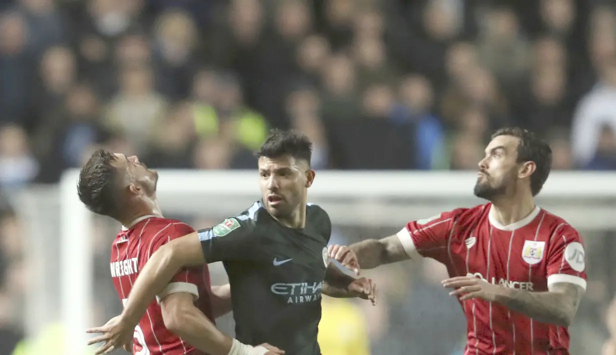 Aksi pemain Manchester City, Sergio Aguero berebut bola dengan dua pemain Bristol City pada semifinal Piala Liga Inggris di Ashton Gate stadium, Bristol,(23/1/2018). Manchester City menang 3-2. (Nick Potts/PA via AP)