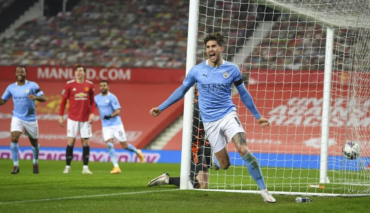 Pemain Manchester City John Stones melakukan selebrasi usai mencetak gol ke gawang Manchester United pada pertandingan semifinal Piala Liga Inggris di Old Trafford, Manchester, Inggris, Rabu (6/1/2021). Manchester City mengalahkan Manchester United 2-0. (Shaun Botterill/Pool via AP)