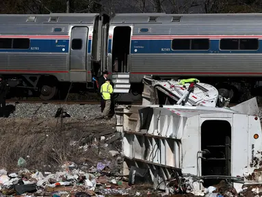 Petugas berada di lokasi kecelakaan kereta api dengan truk sampah di Crozet, Va, (31/1). Kereta penumpang Amtrak yang membawa puluhan anggota parlemen GOP ke sebuah retret Partai Republik di West Virginia menabrak sebuah truk sampah. (Zack Wajsgrasu/AP)