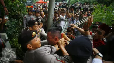 Seorang pria yang diduga provokator diamankan dari amukan massa saat sidang kasus penistaan agama di Jakarta, Selasa (10/1). Sempat terjadi kericuhan akibat peristiwa tersebut. (Liputan6.com/Immanuel Antonius)