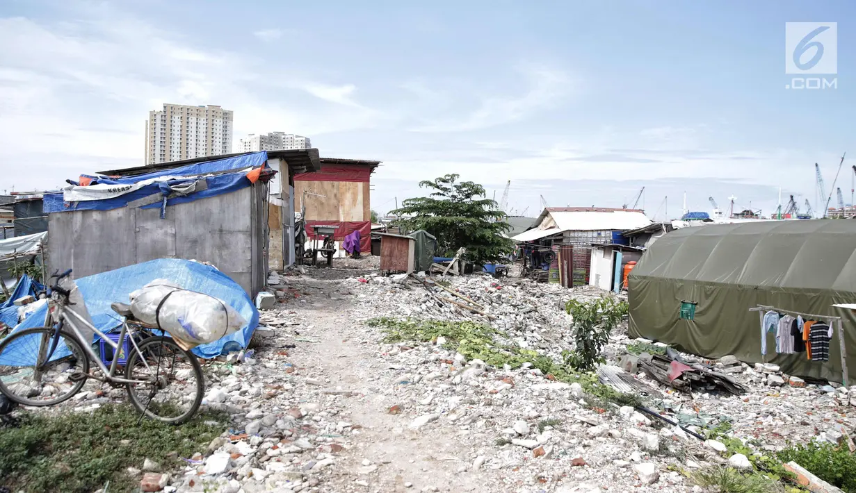 Pemandangan bangunan semi permanen di Kampung Akuarium dengan latar belakang apartemen di Jakarta, Rabu (6/11). Rumah berlapis itu nantinya akan dibangun dengan konsep land consolidation atau konsolidasi lahan. (Liputan6.com/Faizal Fanani)