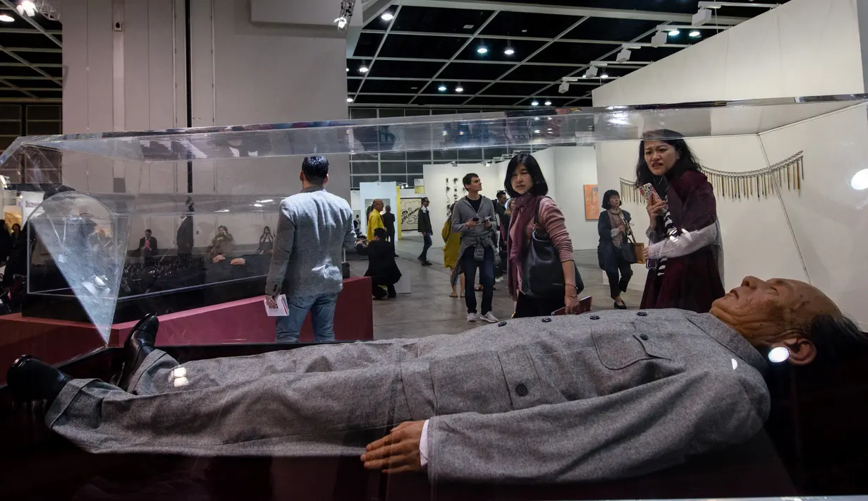 Pengunjung melihat replika Mao Zedong karya seniman Tiongkok yang bernama Shen Shaomin yang dipamerkan dalam Art Basel di Hong Kong (22/3). Karya replika sejumlah tokoh diktator ini banyak menyita perhatian pengunjung. (AFP/Anthony Wallace)