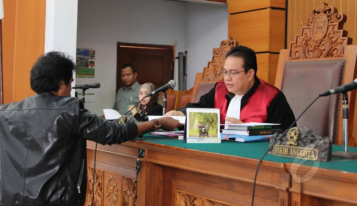 Ahli hukum tata negara Margarito memberikan berkas kepada hakim saat menjalani sidang sebagai saksi ahli dalam Sidang lanjutan praperadilan mantan Menteri ESDM, Jero Wacik di PN Jakarta Selatan, Jakarta, Rabu (22/4/2015).(Liputan6.com/Helmi Afandi)