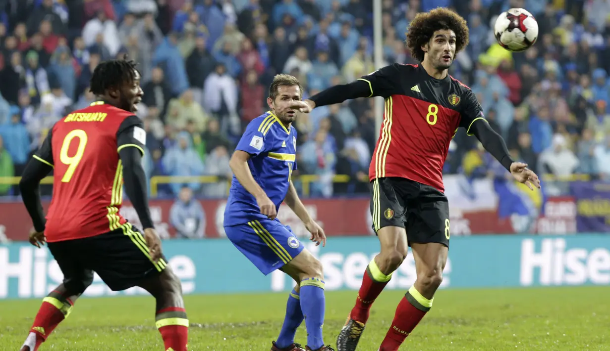 Pemain Belgia, Marouane Fellaini (kanan) mengontrol bola dari kejaran pemain Bosnia, Senad Lulic (tengah) pada kualifikasi Piala Dunia 2018 grup H di Grbavica stadium, Sarajevo, Bosnia, (7/10/2017). Belgia menang 4-3. (AP/Amel Emric)