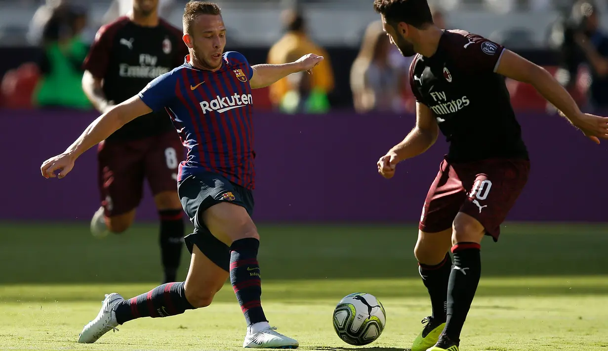 Gelandang Barcelona Arthur Melo berusaha melewati pemian AC Milan Hakan Calhanoglu saat bertanding pada International Champions Cup di Levi's Stadium di Santa Clara, California (4/8). Milan menang tipis 1-0 atas Barcelona. (AFP Photo/Lachlan Cunningham)