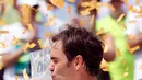 Petenis Swiss, Roger Federer mencium trofi usai memenangkan pertandingan pada final Miami Terbuka di Crandon Park, Florida (2/4). Federer menundukkan rival lamanya, Rafael Nadal dua set langsung 6-3, 6-4. (AP Photo/Wilfredo Lee)