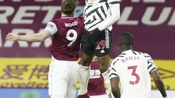 Bek Manchester United, Aaron Wan-Bissaka melompat saat berebut bola dengan penyerang Burnley Chris Wood dalam lanjutan Liga Inggris di Turf Moor, Rabu (13/1/2021) dini hari WIB. Manchester United sukses mengalahkan Burnley dengan skor tipis 1-0. (AP Photo/Jon Super, Pool)