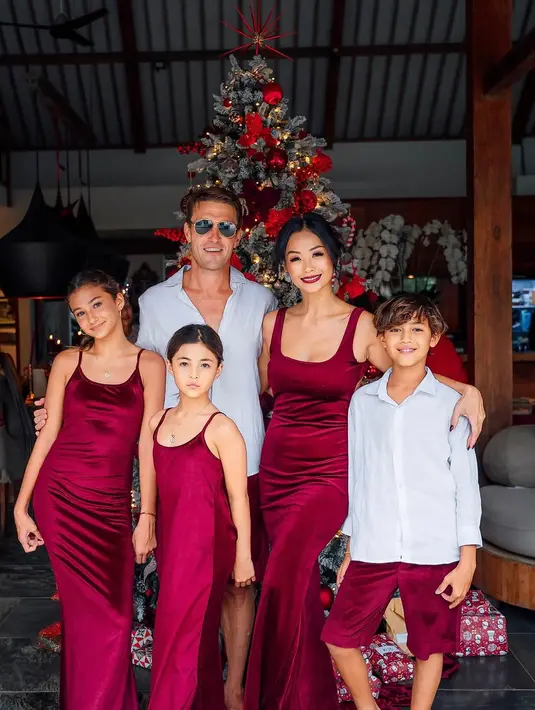 Indah Kalalo dan keluarga mengambil warna Santa Claus sebagai dresscode foto keluarga. Indah dan kedua putrinya kenakan dress satin berwarna merah, sedangkan suami dan putranya kompak padukan kemeja putih dan celana pendek merah [@indahkalalo]