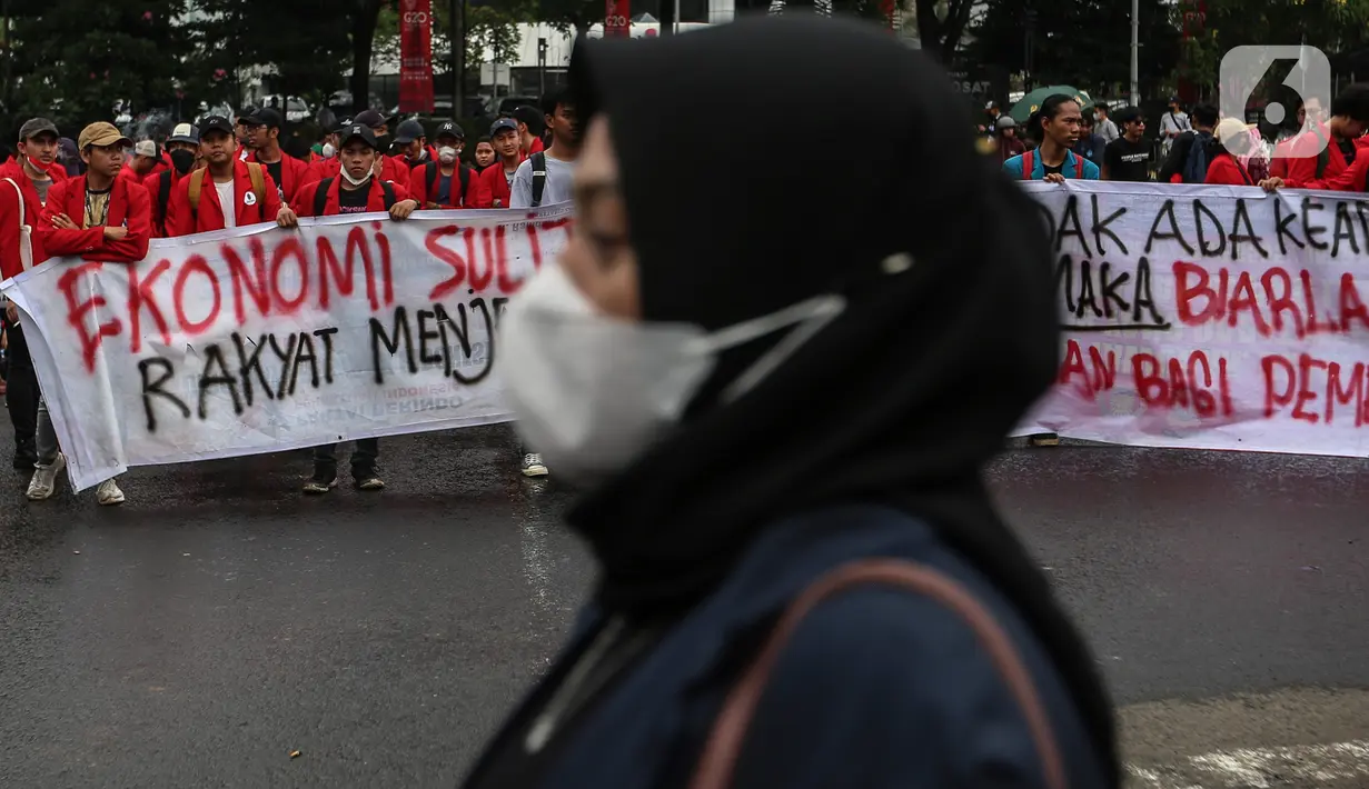 Mahasiswa membentangkan spanduk penolakan kenaikan harga BBM saat menggelar demo di kawasan Patung Kuda, Jakarta Pusat (Jakpus), Kamis (8/9/2022). Pihak kepolisian tetap mengawal jalannya aksi dengan membuat pertahanan berlapis. (Liputan6.com/Johan Tallo)