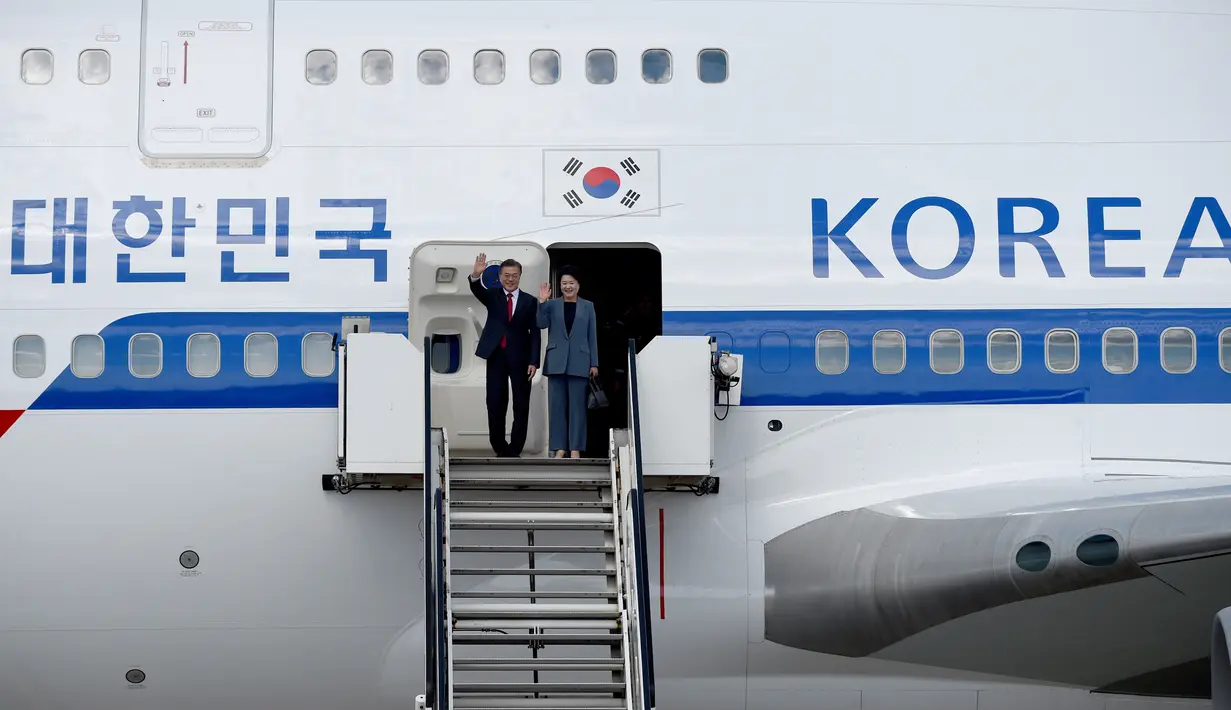 Presiden Korea Selatan, Moon Jae-in dan istrinya, Kim Jung-sook, melambaikan tangan setibanya di Hamburg, Jerman, Kamis (6/7). Sejumlah kepala negara telah tiba di Hamburg jelang pembukaan KTT G20 pada 7-8 Juli 2017. (Carsten Rehder / dpa via AP)