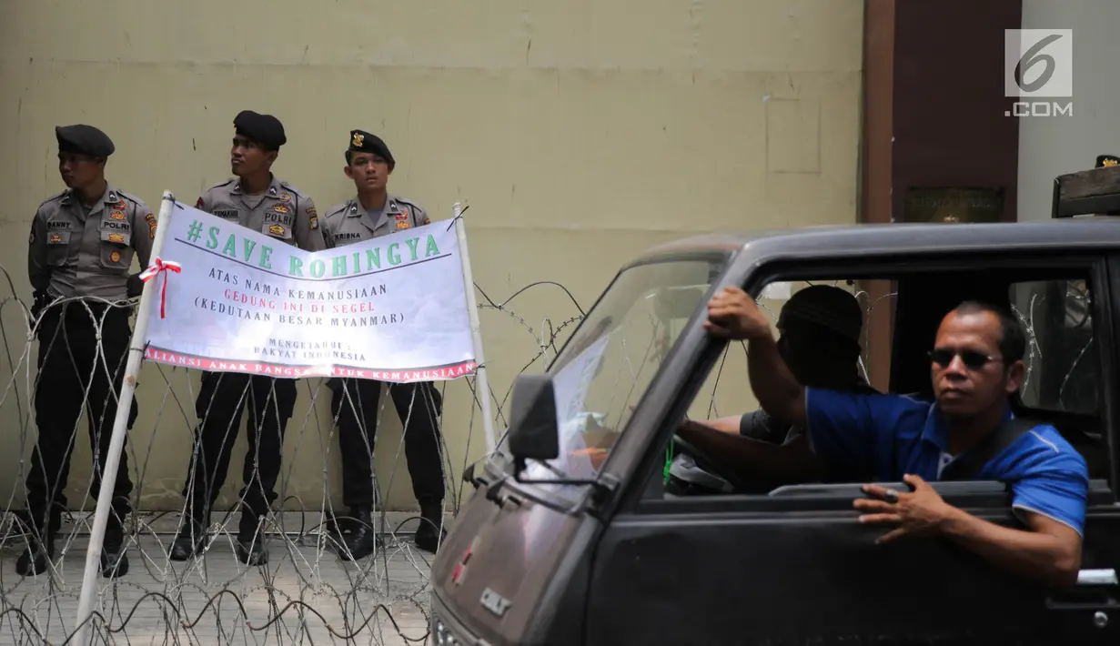 Kendaraan melintas di depan spanduk sebagai tanda penyegelan kantor Kedubes Myanmar di Jakarta, Selasa (5/9). Aksi tersebut sebagai bentuk protes terhadap pemerintah Myanmar terkait  kekerasan terhadap etnis rohingya. (Liputan6.com/Faizal Fanani)