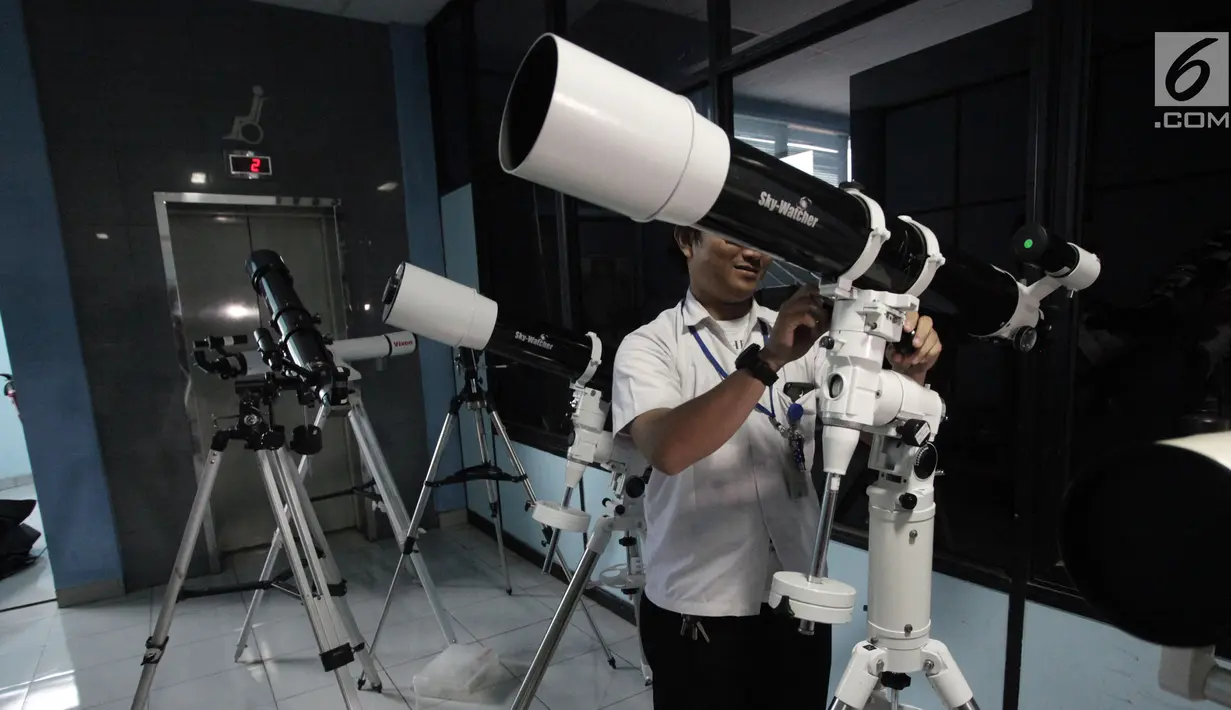 Petugas mempersiapkan teleskop yang akan digunakan untuk melihat fenomena Supermoon di Planetarium Jakarta, Selasa (30/1). Planetarium Jakarta menggelar nonton bareng fenomena Supermoon dengan menyiapkan 16 teleskop. (Liputan6.com/Arya Manggala)