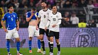 Gelandang Jerman #10, Jamal Musiala (Kanan), merayakan gol 2-0 bersama rekan setimnya penyerang Jerman #09, Tim Kleindienst, selama pertandingan leg kedua perempat final UEFA Nations League antara Jerman dan Italia di stadion Signal Iduna Park di Dortmund, Jerman Barat, Senin dini hari WIB (23-3-2025). (Kirill KUDRYAVTSEV/AFP)