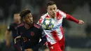 Gelandang Bayern Munchen, Kingsley Coman (kiri) berebut bola dengan pemain Crvena Zvezda, Milan Rodic  pada pertandingan Grup B Liga Champions di Stadion Rajko Mitic, Belgrade, Serbia (26/11/2019). Munchen menang telak 0-6 atas Crvena Zvezda. (AFP/Pedja Milosavljevic)