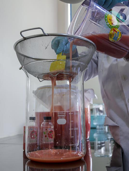 Peneliti menuangkan jambu merah yang telah diblender sebelum difermentasi di Kimia Pangan Pusat Penilitian Kimia LIPI Puspitek, Serpong, Tangerang, Kamis (4/6/2020). Fermentasi jambu memiliki kandungan polifenol, flavonoid, antioksidan dan asam organik. (Liputan6.com/Fery Pradolo)
