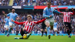 Pemain Brentford Mads Roerslev (kiri) berebut bola dengan pemain Manchester City Phil Foden pada pertandingan sepak bola Liga Inggris di Etihad Stadium, Manchester, Inggris, 12 November 2022. Manchester City kalah 1-2 dari Brentford. (AP Photo/Dave Thompson)