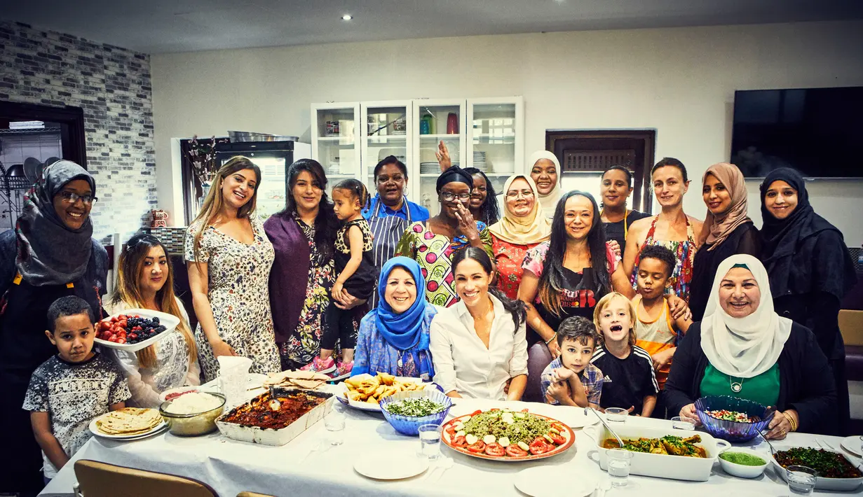 Meghan Markle foto bersama para anggota Hubb Community Kitchen di Al Manaar Muslim Cultural Heritage Centre, London, Inggris (19/7). Istri Pangeran Harry ini rutin mengikuti kegiatan ini sejak Januari 2018. (Jenny Zarins/Kensington Palace via AP)