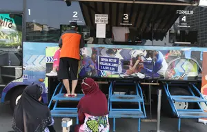 Warga membayar pajak kendaraan bermotor di gerai Samsat Keliling Car Free Day, Jakarta, Minggu (21/10). Agar bisa membayar pajak ini cukup menggunakan STNK dengan nama yang tertera harus sesuai KTP. (Liputan6.com/Angga Yuniar)
