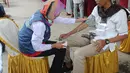 Petugas medis Puskesmas memeriksa tekanan darah petugas Kelompok Penyelenggara Pemungutan Suara (KPPS) yang bertugas saat pemungutan suara ulang di TPS 49 Rengas, Ciputat Timur, Tangsel, Rabu (24/4). Pemeriksaan untuk antisipasi menurunnya kesehatan fisik akibat kelelahan. (merdeka.com/Arie Basuki)