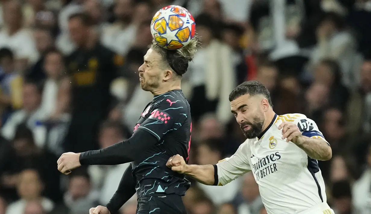 Gelandang Manchester City, Jack Grealish (kiri) memenangi duel udara dengan bek Real Madrid, Dani Carvajal pada laga leg pertama babak perempatfinal Liga Champions 2023/2024 di Santiago Bernabeu Stadium, Selasa (9/4/2024) malam. (AP Photo/Manu Fernandez)