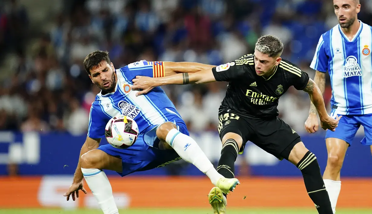 Gelandang Real Madrid, Federico Valverde berebut bola dengan pemain Espanyol, Leandro Cabrera pada pertandingan lanjutan La Liga Spanyol di stadion Camp Nou di Barcelona, Spanyol, Senin (29/8/2022). Benzema mencetak dua gol dan mengantar Madrid menang atas Espanyol 3-1. (AP Photo/Joan Mateu Parra)