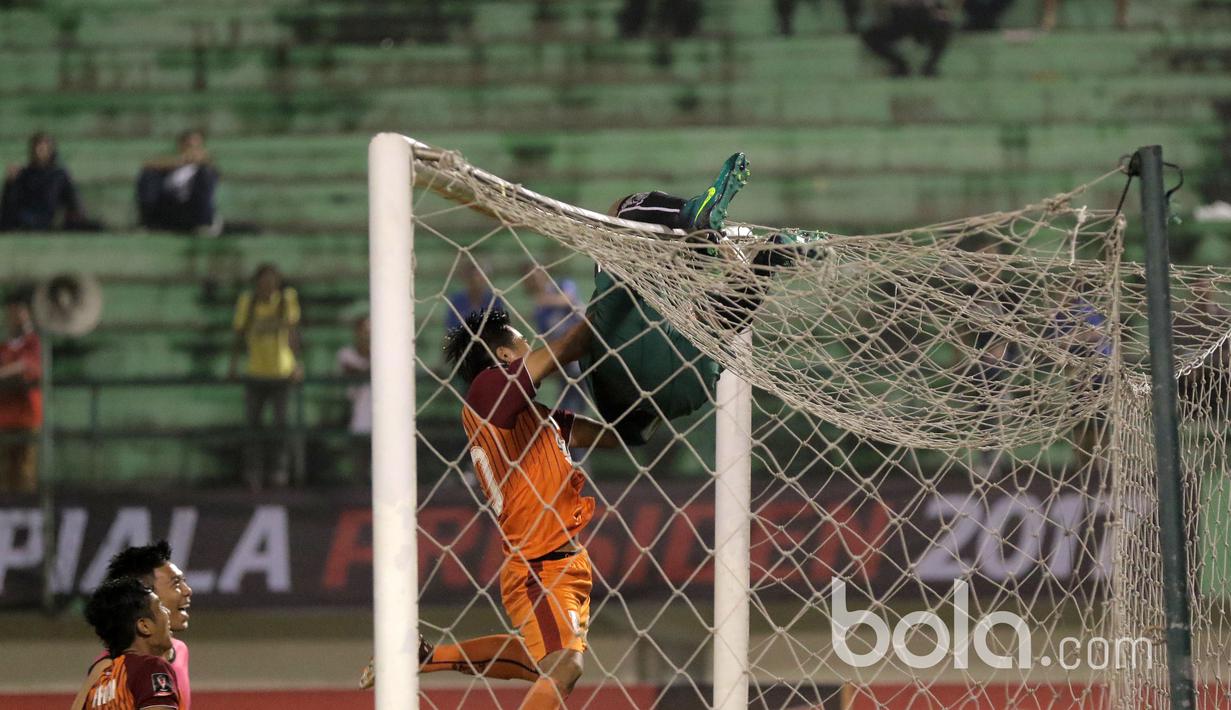 Aksi Kiper Pusamania Borneo FC, Wawan merayakan kemenangan dengan memanjat gawang usai mengalahkan Madura United lewat adu penalti pada babak delapan besar Piala Presiden 2017 di Stadion Manahan, Solo. Jumat (25/2/2017). (Bola.com/Nicklas Hanoatubun)