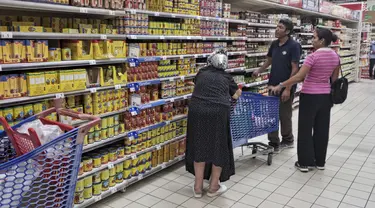 Orang-orang berbelanja di sebuah supermarket, di Tunis, Tunisia, pada 10 Oktober 2022. Gula, minyak sayur, beras, bahkan air kemasan – warga Tunisia telah menderita kekurangan beberapa bahan pokok dalam beberapa pekan terakhir. Dan biaya melonjak pada produk yang masih tersedia. (AP Photo/Hassene Dridi)