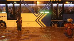 Bus Transjakarta menerobos banjir di terowongan (underpass) Cawang, Jalan MT Haryono, Jakarta, Selasa (12/12). Hujan deras dan buruknya drainase di kawasan tersebut menjadi penyebab utama adanya genangan air hingga 50 cm. (Liputan6.com/Herman Zakharia)