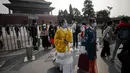 Wanita mengenakan kostum tradisional keluar dari Kota Terlarang selama di Beijing (7/10/2020). Liburan tahun ini, yang bertepatan dengan Festival Pertengahan Musim Gugur, akan menjadi ujian lakmus apakah industri pariwisata China dapat bangkit kembali setelah digempur COVID-19. (AP Photo/Andy Wong)