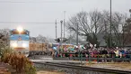Warga memberi penghormatan saat kereta pembawa peti jenazah Presiden ke-41 AS George HW Bush di Navasota, Texas, Kamis (6/12). Jenazah mantan presiden AS George HW Bush dibawa menggunakan kereta pemakaman khusus. (AP Photo/Gerald Herbert)