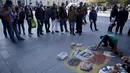 Seniman Chili melukis tindakan provokasi Gonzalo Jara terhadap pemain Uruguay, Edinson Cavani di trotoar jalan di Santiago, Chili (28/6/2015). Hal ini merupakan bentuk protes warga Chili terhadap aksi provokasi Bek Gonzalo Jara. (REUTERS/Marcos Brindicci)