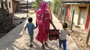 Savita Kedar ditemani oleh cucunya usai menimba ilmu di Sekolah Aajibaichi Shaala, Desa Fangane, India, pada 1 Maret 2017. Sekolah ini memulai kegiatan belajar sekitar pukul dua siang waktu setempat. (AFP Photo / Indranil Mukherjee)