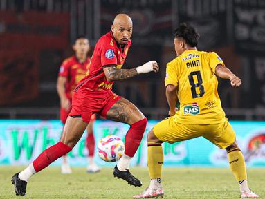 Pemain Persija Jakarta, Gustavo Almeida mencoba melewati pemain Semen Padang Ricki Ariansyah pada laga pekan ke-30 Liga 1 2024/2025 di Stadion Pakansari, Kabupaten Bogor, Minggu (27/4/2025). (Bola.com/Abdul Aziz)