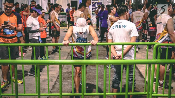 Peserta pemanasan sebelum mengikuti Jakarta Marathon 2018 di Gelora Bung Karno, Jakarta, Minggu (28/10). Sebanyak 12.500 pelari meramaikan Jakarta Marathon 2018, Memasuki tahun keenam, Jakarta Marathon yang di sponsori PLN. (Liputan6.com/Faizal Fanani)